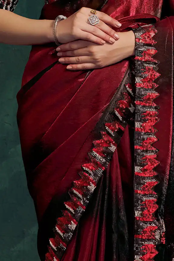 Crimson silk saree with onyx sequin border and ornate embellishment details