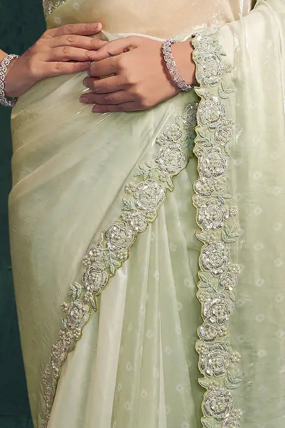 Mint sage saree close-up of hands and ornate floral border along pleats