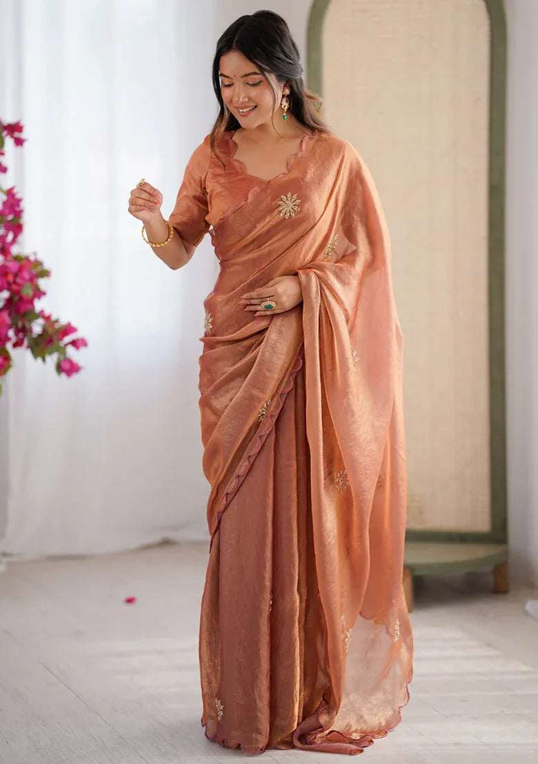 Rust satin saree with beaded floral/star motifs and embellished pallu border