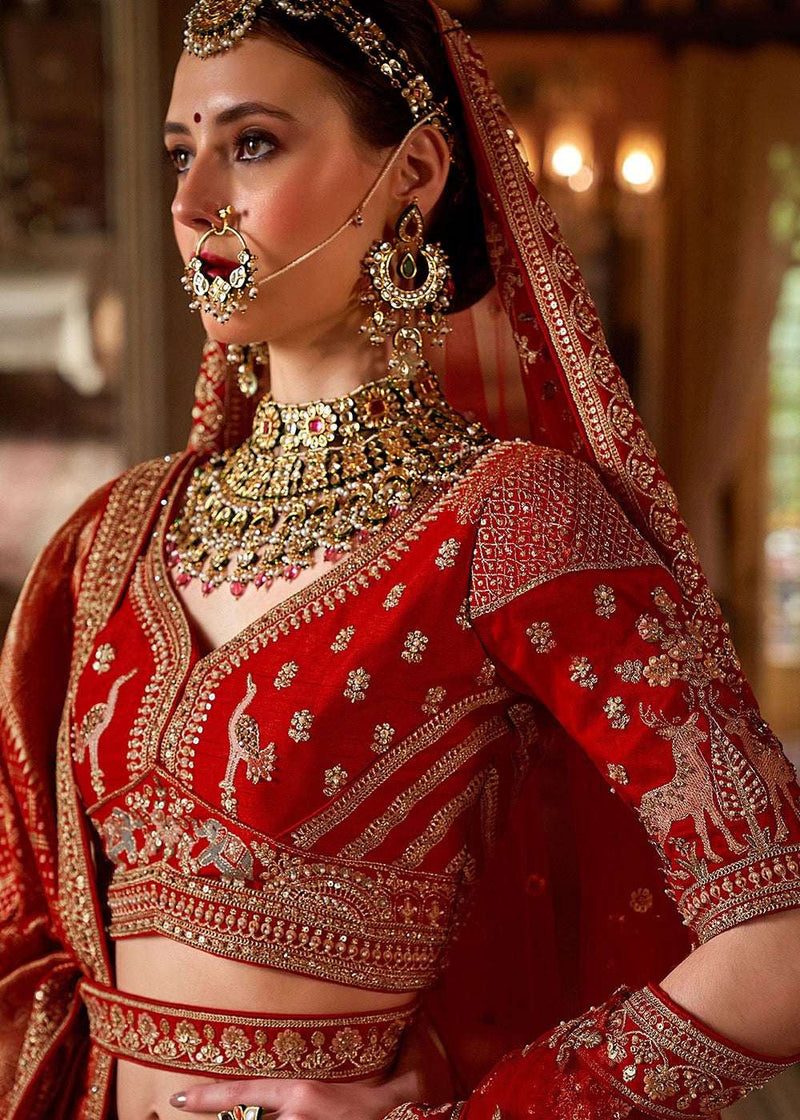 Crimson red embroidered bodice with deer motifs, gold trim, matching dupatta border