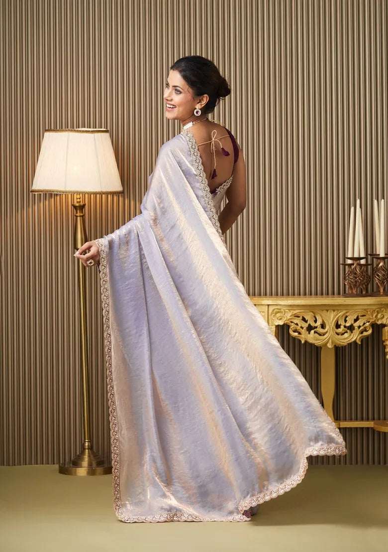 Silver satin saree drape with gold border, shown from back with maroon blouse