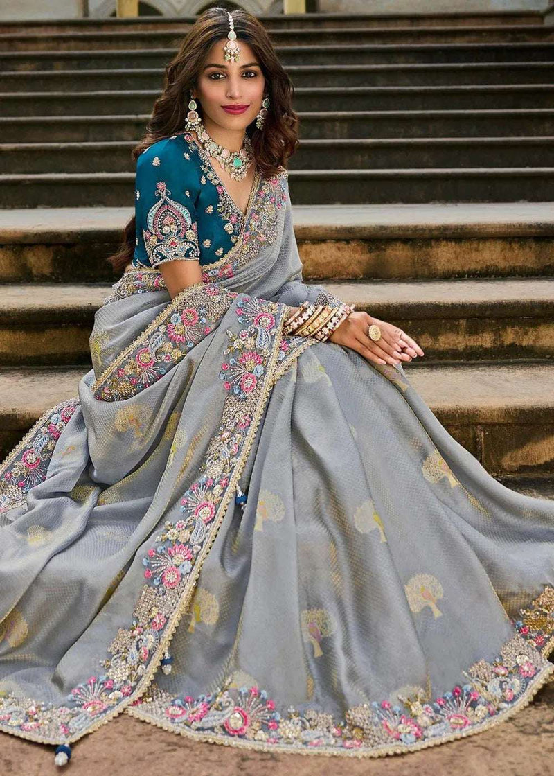 Grey silk saree with teal blouse, ornate mirrorwork floral border and cutwork, full drape