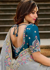 Back of teal blouse with grey saree, embroidered border and mirrorwork motifs, draped