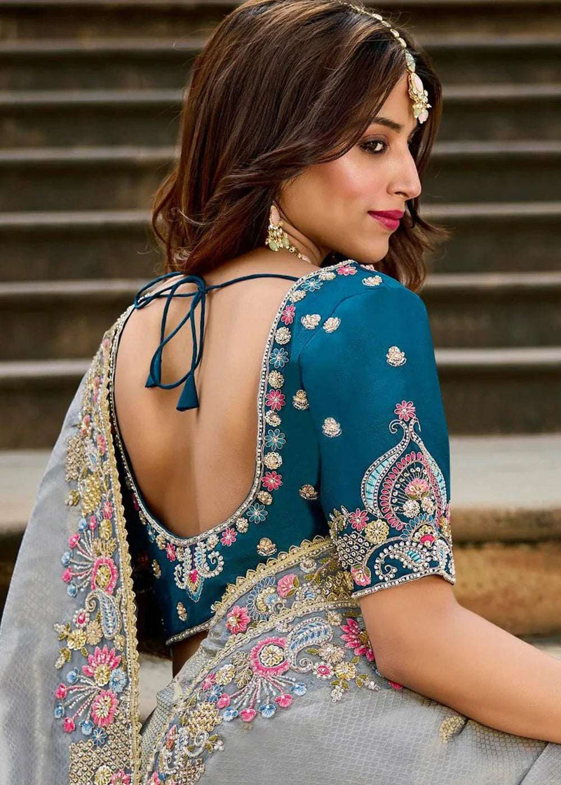 Back of teal blouse with grey saree, embroidered border and mirrorwork motifs, draped