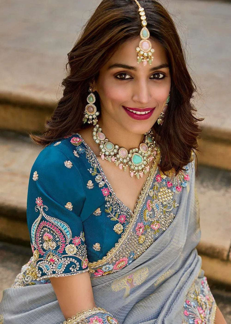 Teal blouse with grey saree pallu, mirrorwork and floral embroidery, draped over shoulder