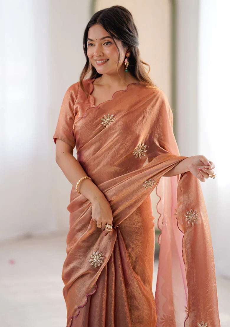 Rust satin saree with beaded chest motif, gathered border, and draped pallu