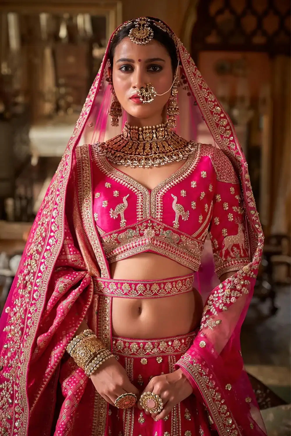 Rani pink bridal lehenga with gold embroidered choli and draped dupatta, jewelry