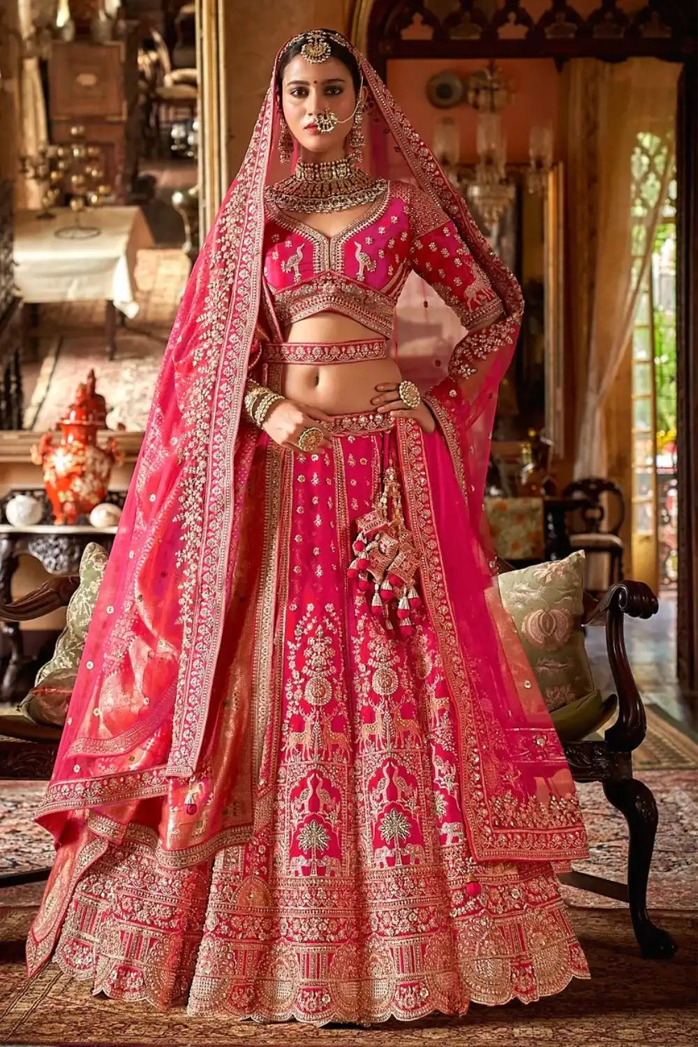 Rani pink bridal lehenga with gold embroidery, embellished choli and flowing dupatta