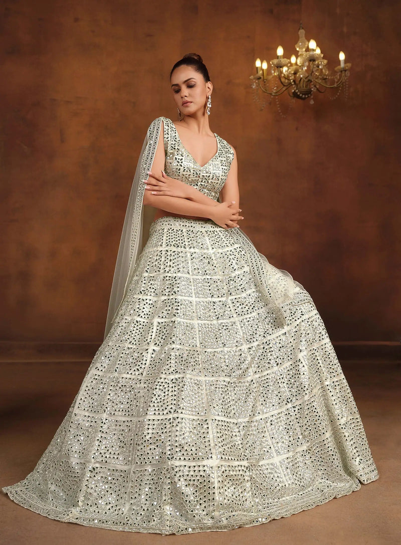 Off-white bridal lehenga with mirror-work sleeveless blouse, tiered skirt, and veil dupatta