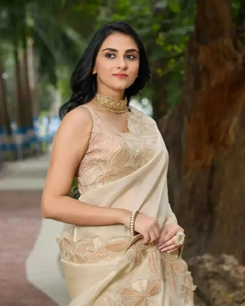 Cream organza saree with gold sequin floral work and draped pallu detailing