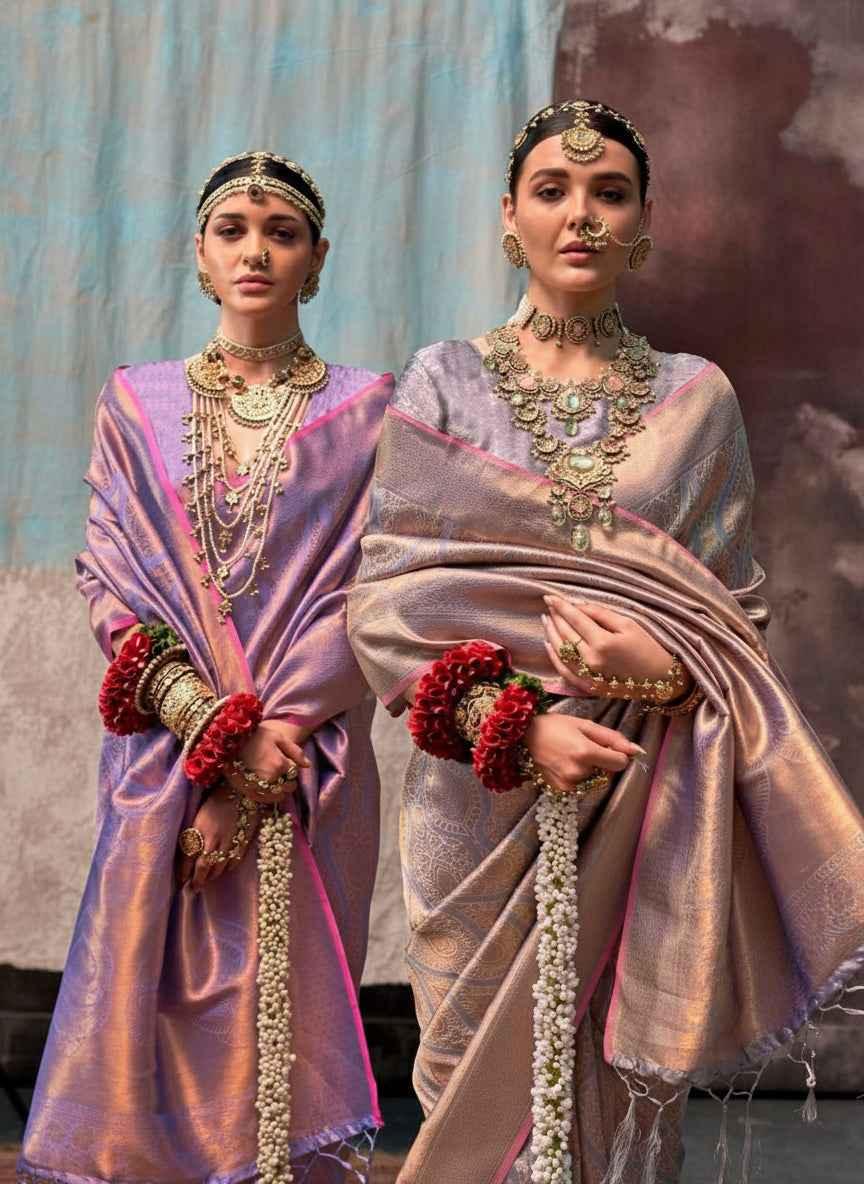 Two women wearing handloom silk sarees with two-tone weave and ornate gold jewelry against a textured backdrop