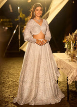 Silver net lehenga set with long-sleeve embellished blouse and flowing flared skirt