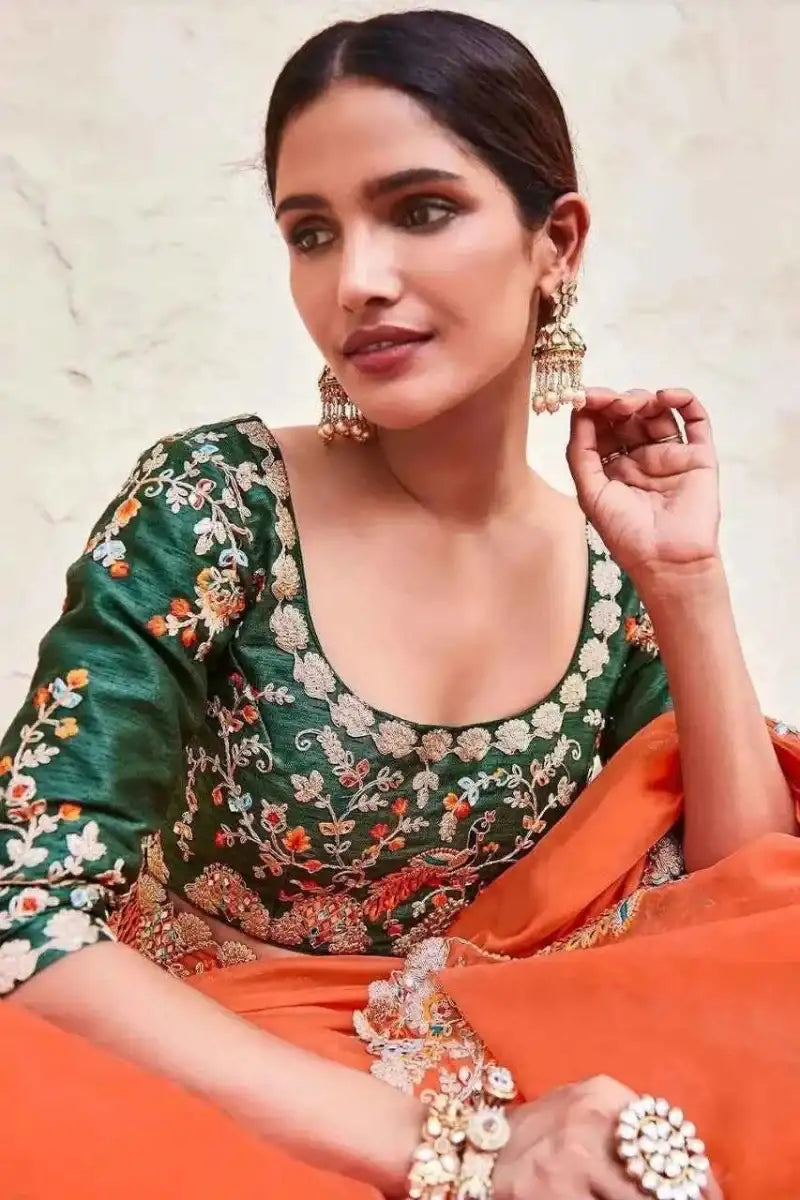 Organza mirror saree detail, dark green floral blouse with orange pallu and mirror trim
