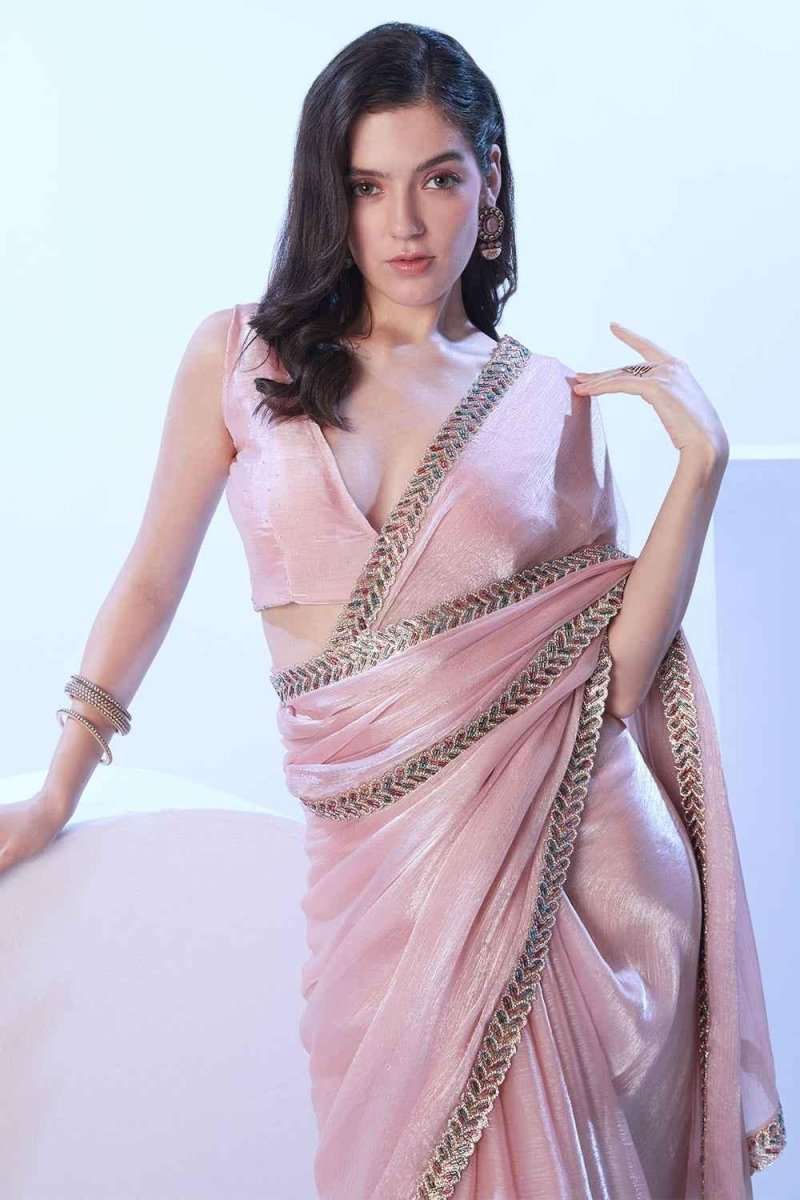 Blush pink shimmer saree with gold-tone trim across neckline and drape