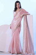 Blush pink shimmer saree with gold-tone border and draped pallu