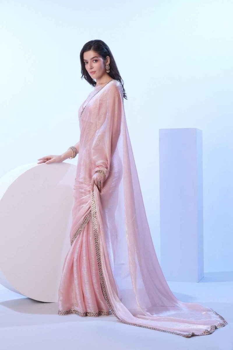 Blush pink shimmer saree with gold-tone border and flowing side drape