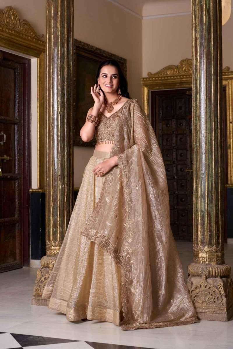 Beige-gold embroidered lehenga set with blouse and flowing dupatta over shoulder