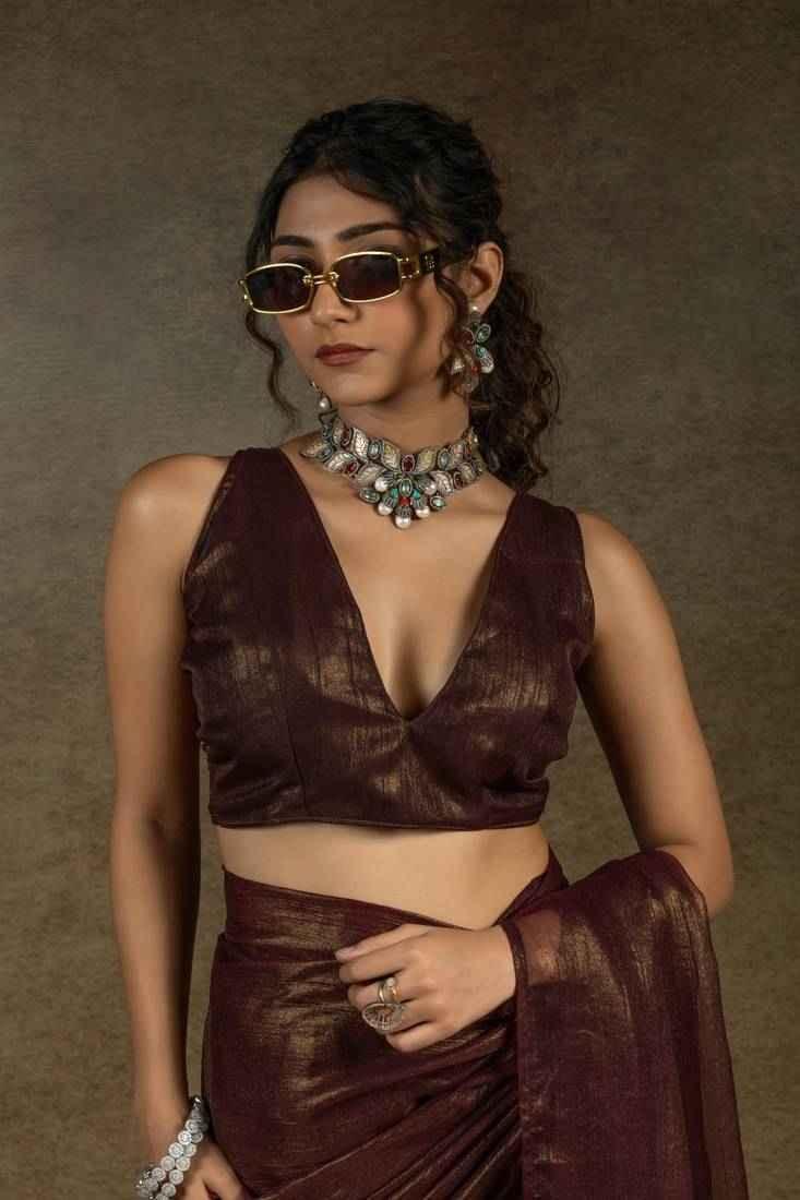 Dark brown satin chiffon saree with gold shimmer, sleeveless blouse and gathered waist