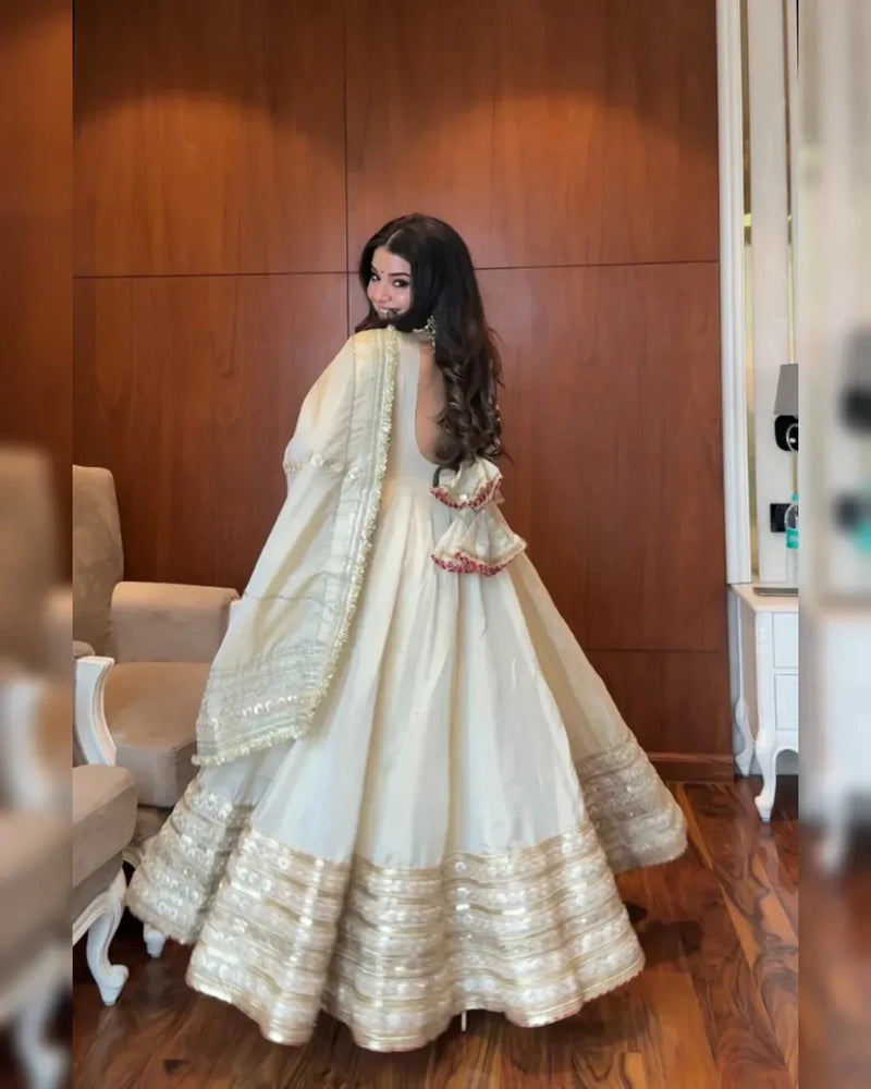 Ivory anarkali dress with gold sequin trim and draped dupatta, side view