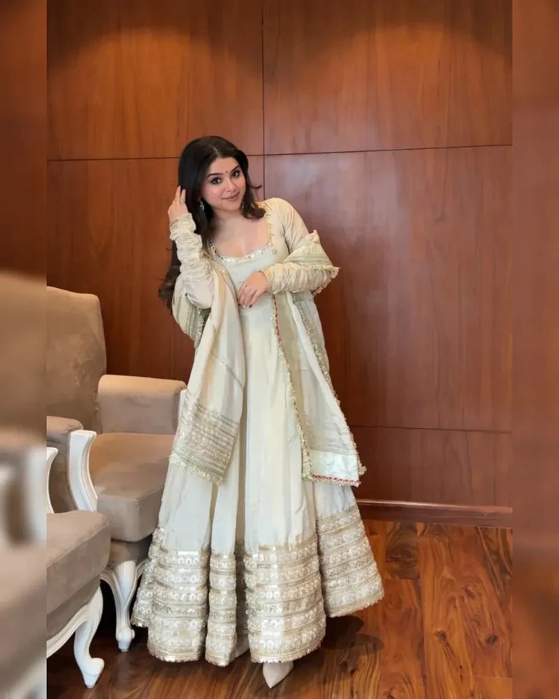 Ivory anarkali suit with gold sequin threadwork, tiered hem, and embellished dupatta