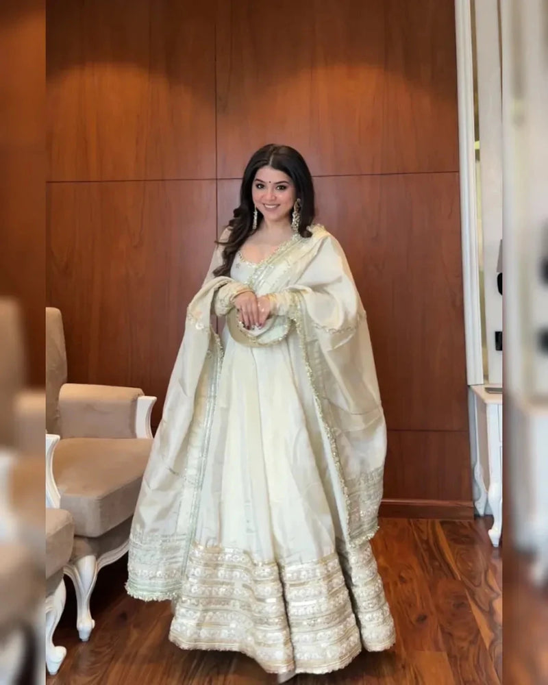 Ivory anarkali suit with gold threadwork borders, round neckline, and full flare