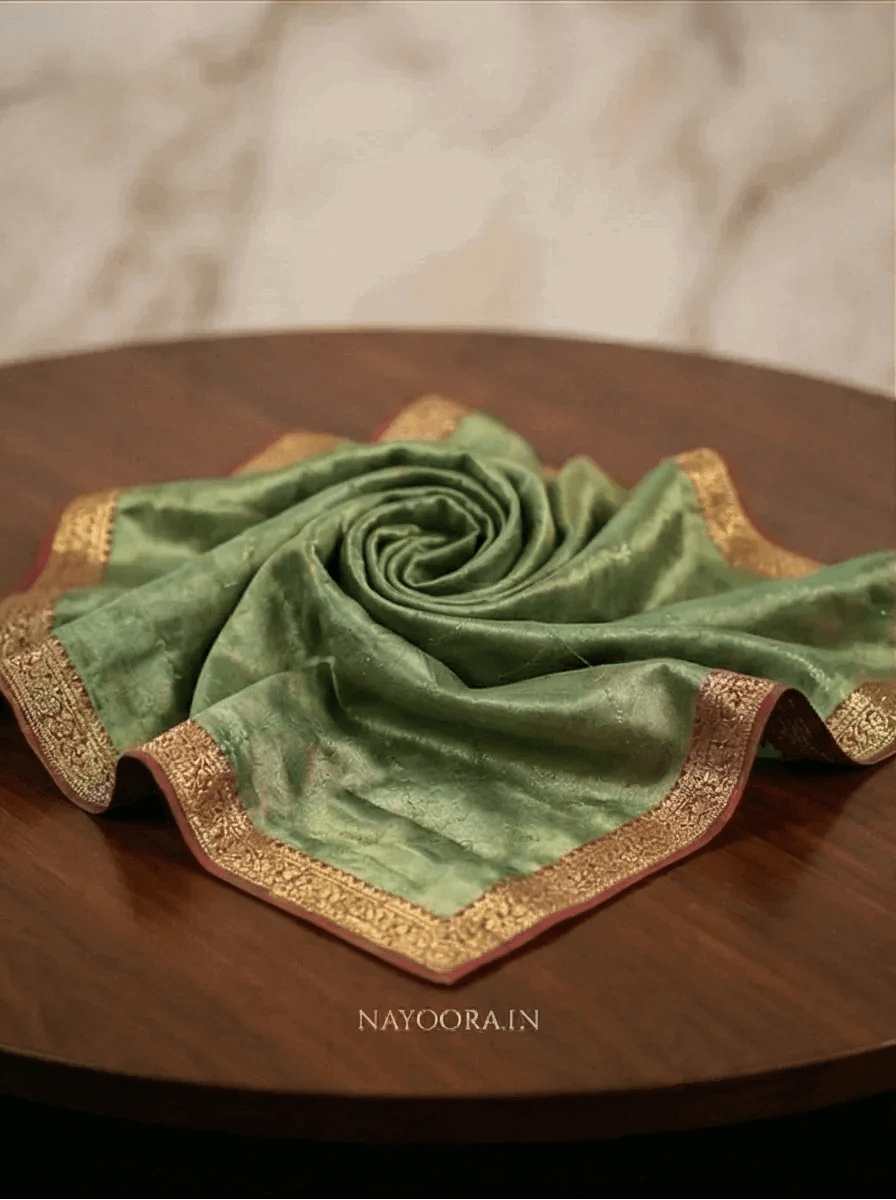 Dual tone tissue silk saree folded, green fabric with gold zari border