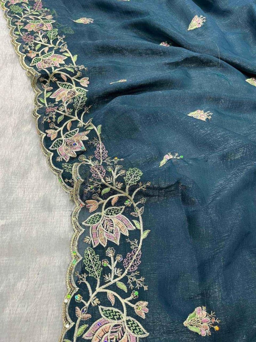 Teal fabric edge with detailed gold, floral embroidery and pastel accents.