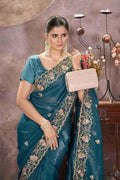 Teal embroidered saree with gold border and short-sleeve blouse, front drape.