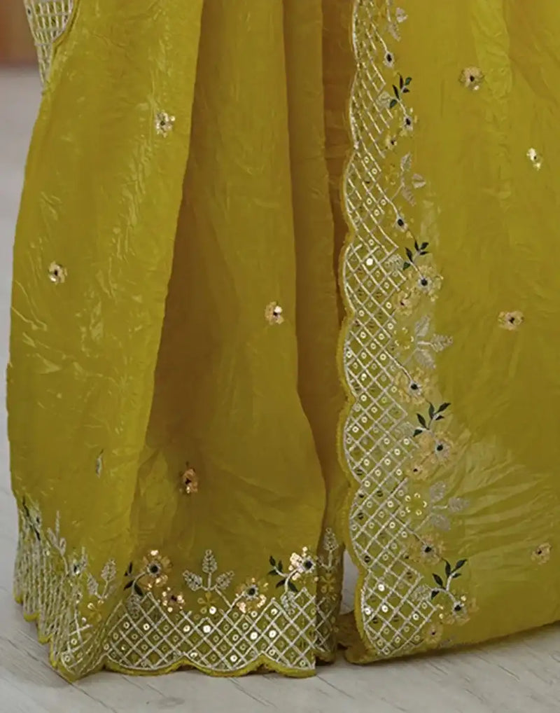 Yellow saree fabric close-up with gold embroidered mesh border and bead motifs