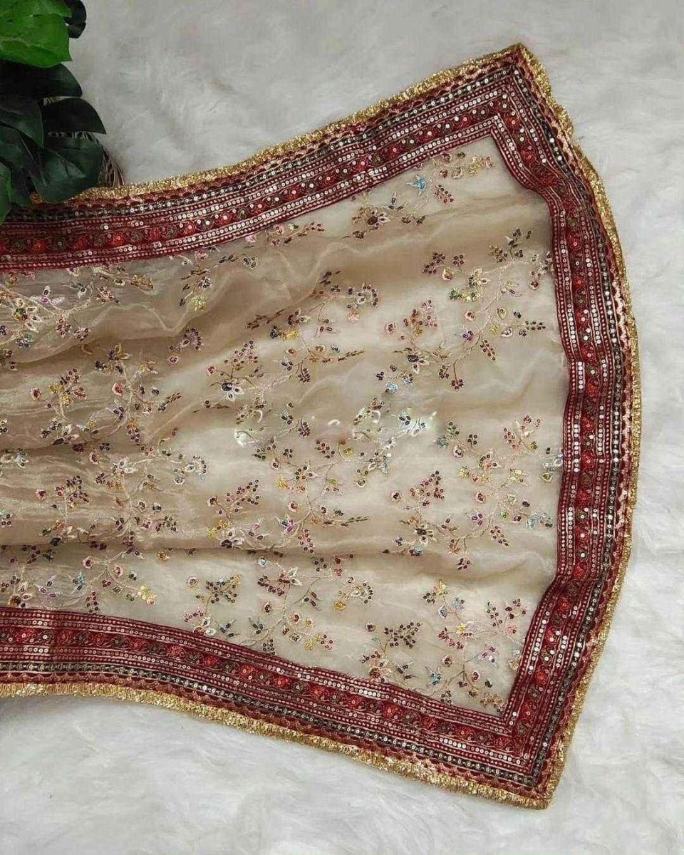 Maroon-edged cream organza saree with dense multicolor floral embroidery and gold zari trim