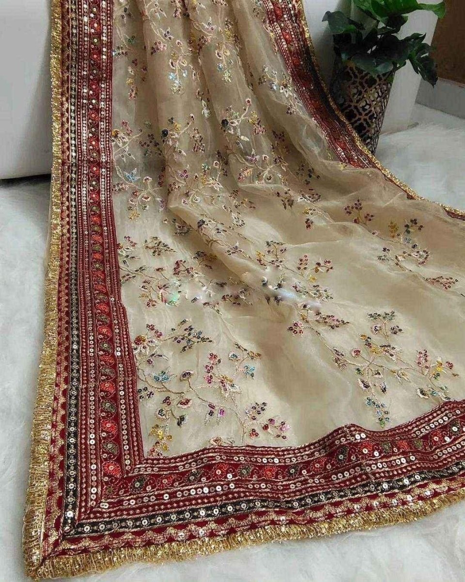 Cream organza saree with maroon border stripe, gold edging, and small multicolor floral motifs