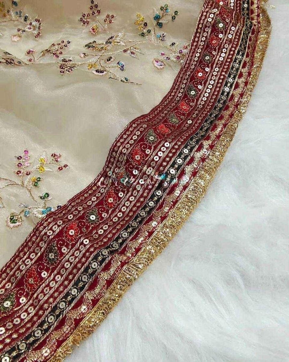 Maroon zari border on cream organza saree with glittering gold edge and bead-like details