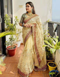 Organza saree in cream with maroon and gold zari border, multicolor floral embroidery
