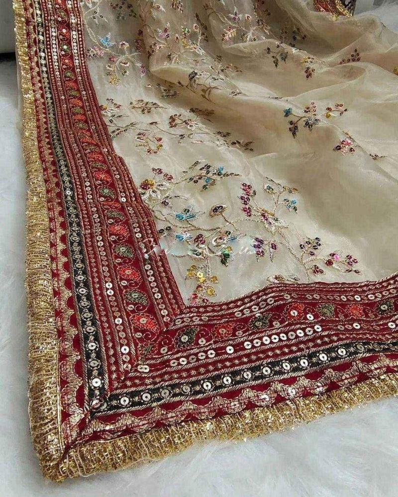 Cream organza saree corner with maroon border, gold trim, and tiny multicolor florals