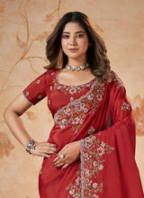 Red wedding saree with gold-and-white floral embroidery on draped pallu and border