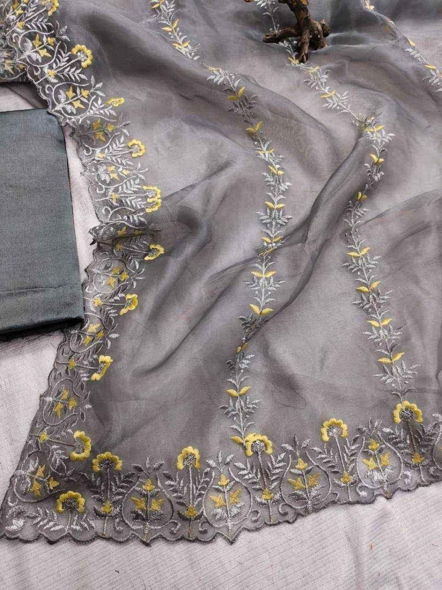 Grey organza fabric with dense yellow floral and leaf embroidery along edges