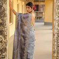 Grey organza saree with floral embroidery and scalloped embroidered border, draped
