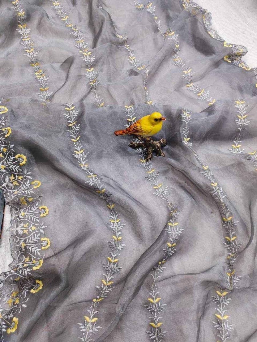 Grey organza saree with scattered yellow floral embroidery and a small yellow bird motif