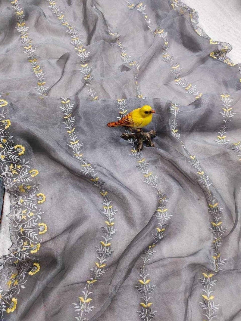 Grey organza saree with scattered yellow floral embroidery and a small yellow bird motif