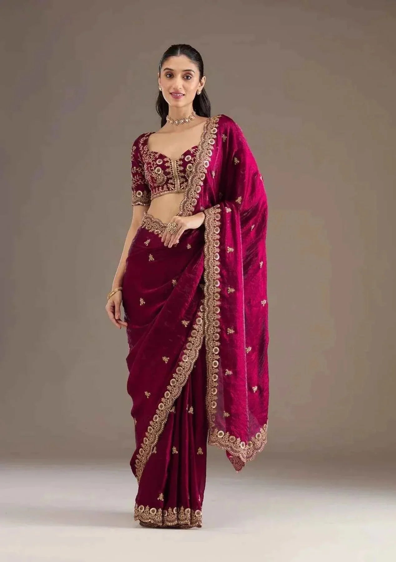 Woman wearing a hot pink satin silk saree with heavy jari cutwork embroidery and matching blouse