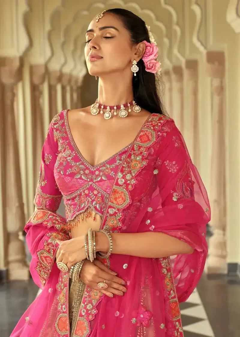Rani pink lehenga blouse with V-neck mirror work, gold trim and sheer dupatta