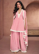 Baby pink printed peplum top with lace trim, wide-leg palazzo, and lace-bordered dupatta