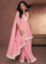Pink printed peplum top with lace trim, palazzo pants, and flowing lace dupatta