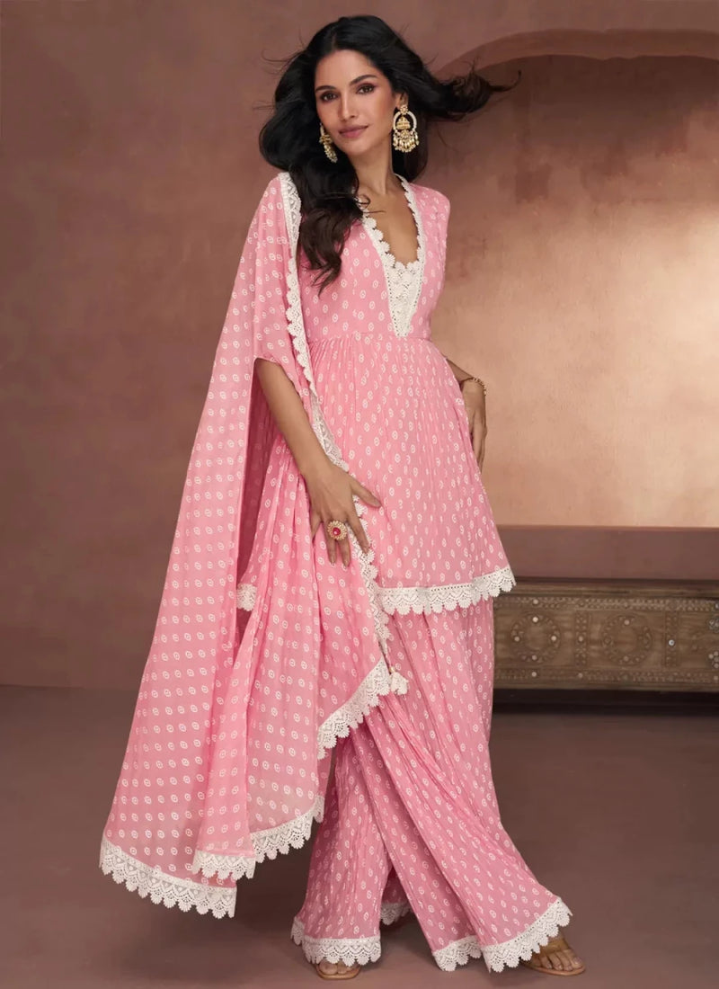 Pink printed peplum top with lace trim, palazzo pants, and flowing lace dupatta