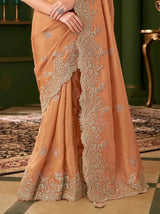 Burnt orange georgette saree with teal embroidered motifs and border at hem
