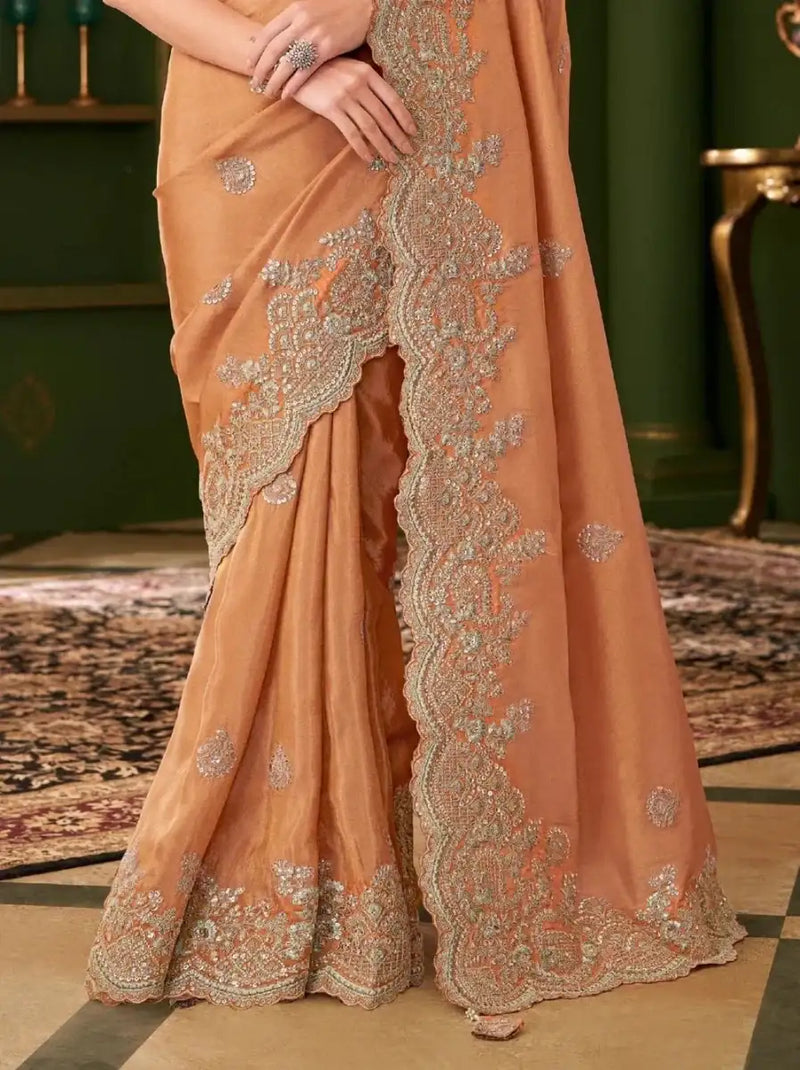 Burnt orange georgette saree with teal embroidered motifs and border at hem