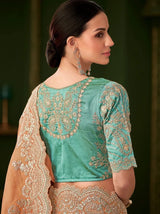 Back view of teal blouse with ornate embroidery and burnt orange saree border
