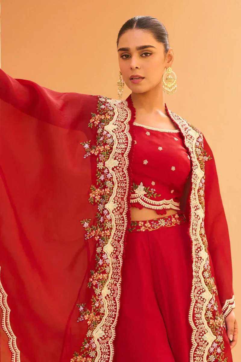 Cherry red embroidered cape with gold-toned floral border over matching top
