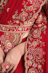 Cherry red saree with ornate gold embroidery belt and detailed floral motifs