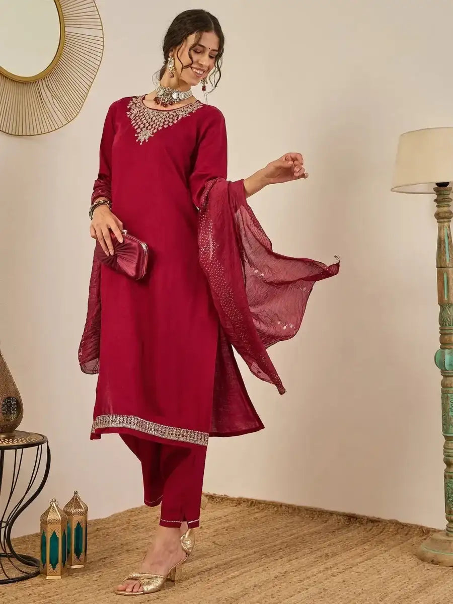 Deep maroon embroidered kurta suit set with leggings and dupatta held at side